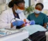 Dentist using an LED curing light and orange protective eyewear during restorative treatment